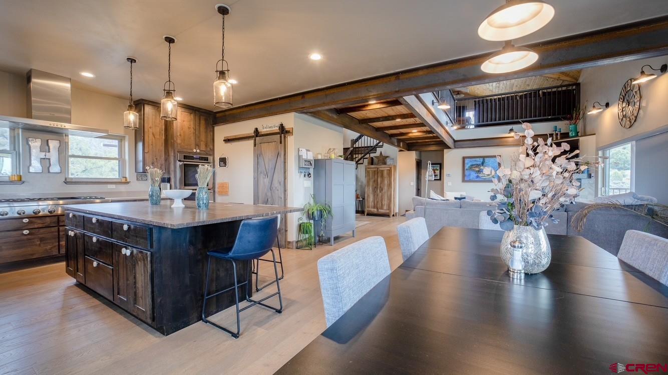 492 Fox Fire Ridge Road Bayfield, CO 81122 - Photo 15 of 44 a kitchen with stainless steel appliances granite countertop a refrigerator a sink dishwasher a dining table and chairs with wooden floor