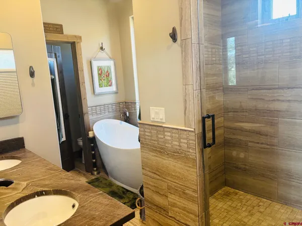 a bathroom with a granite countertop sink a toilet a mirror and shower
