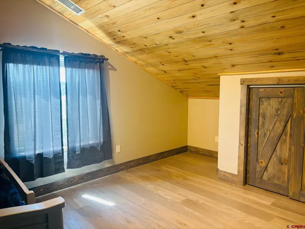 a work room with furniture a rug and a window