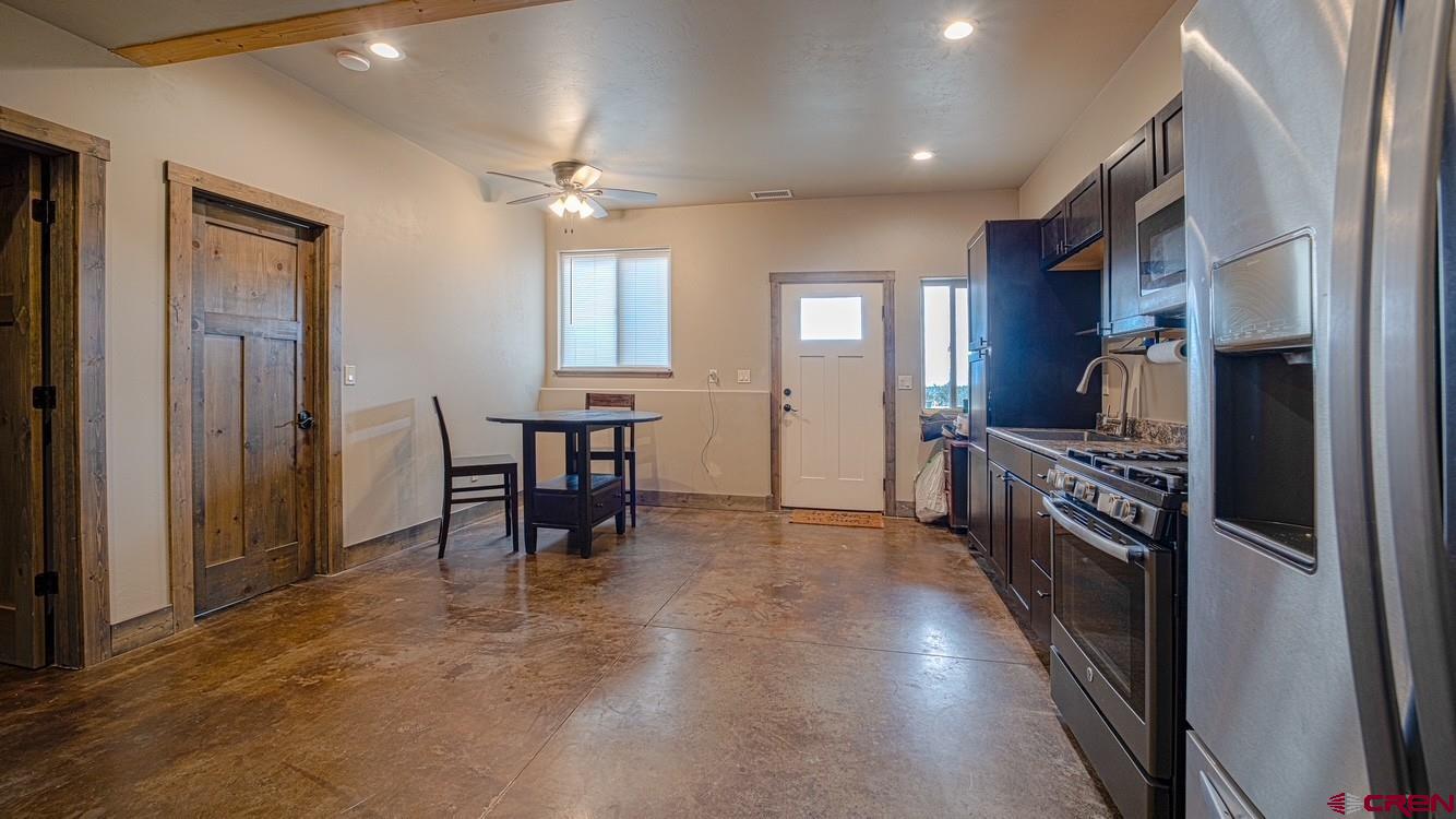 492 Fox Fire Ridge Road Bayfield, CO 81122 - Photo 32 of 44 a kitchen with a table chairs refrigerator and cabinets
