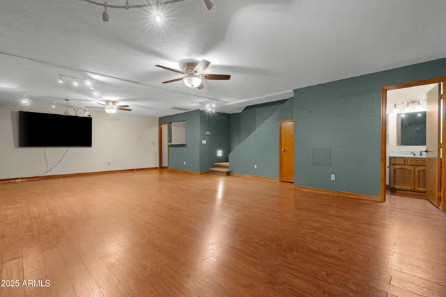 a view of an empty room with a chandelier fan