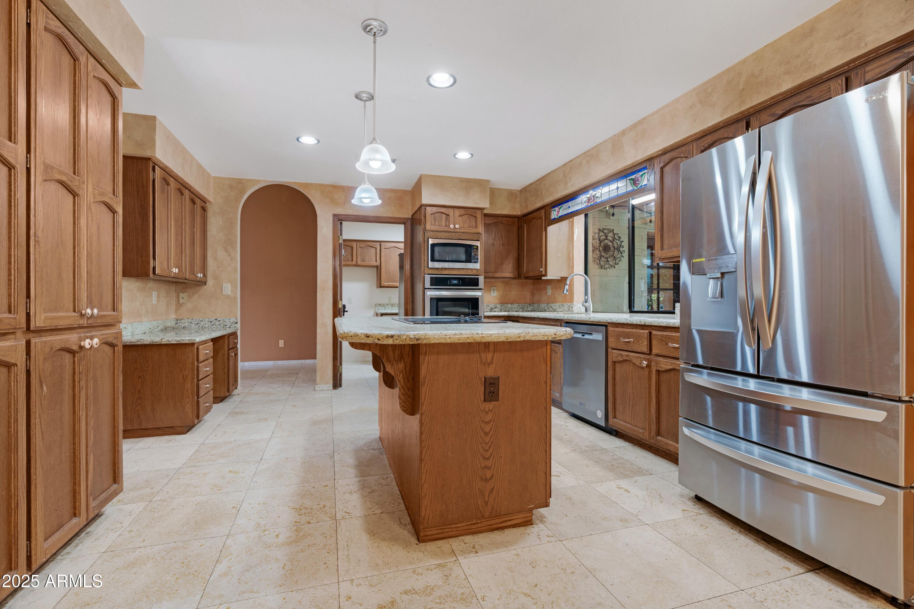 3152 East Irwin Avenue Mesa, AZ 85204 - Photo 9 of 39 a large kitchen with stainless steel appliances kitchen island granite countertop a large counter top stainless steel appliances and cabinets