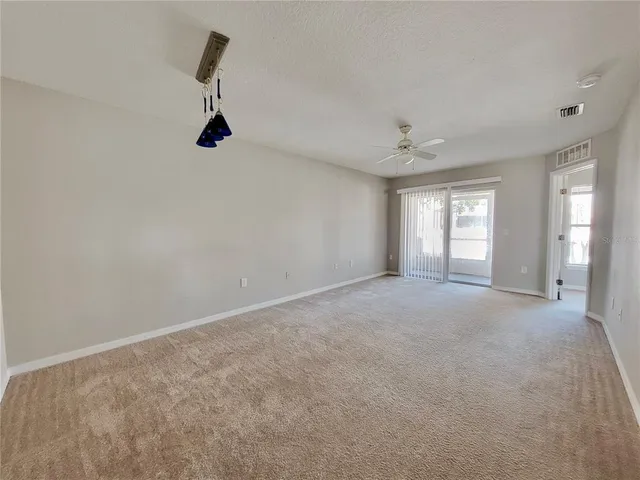 a view of a big room with windows and chandelier fan