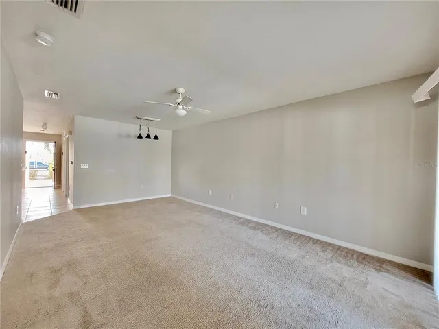 an empty room with a ceiling fan and a window