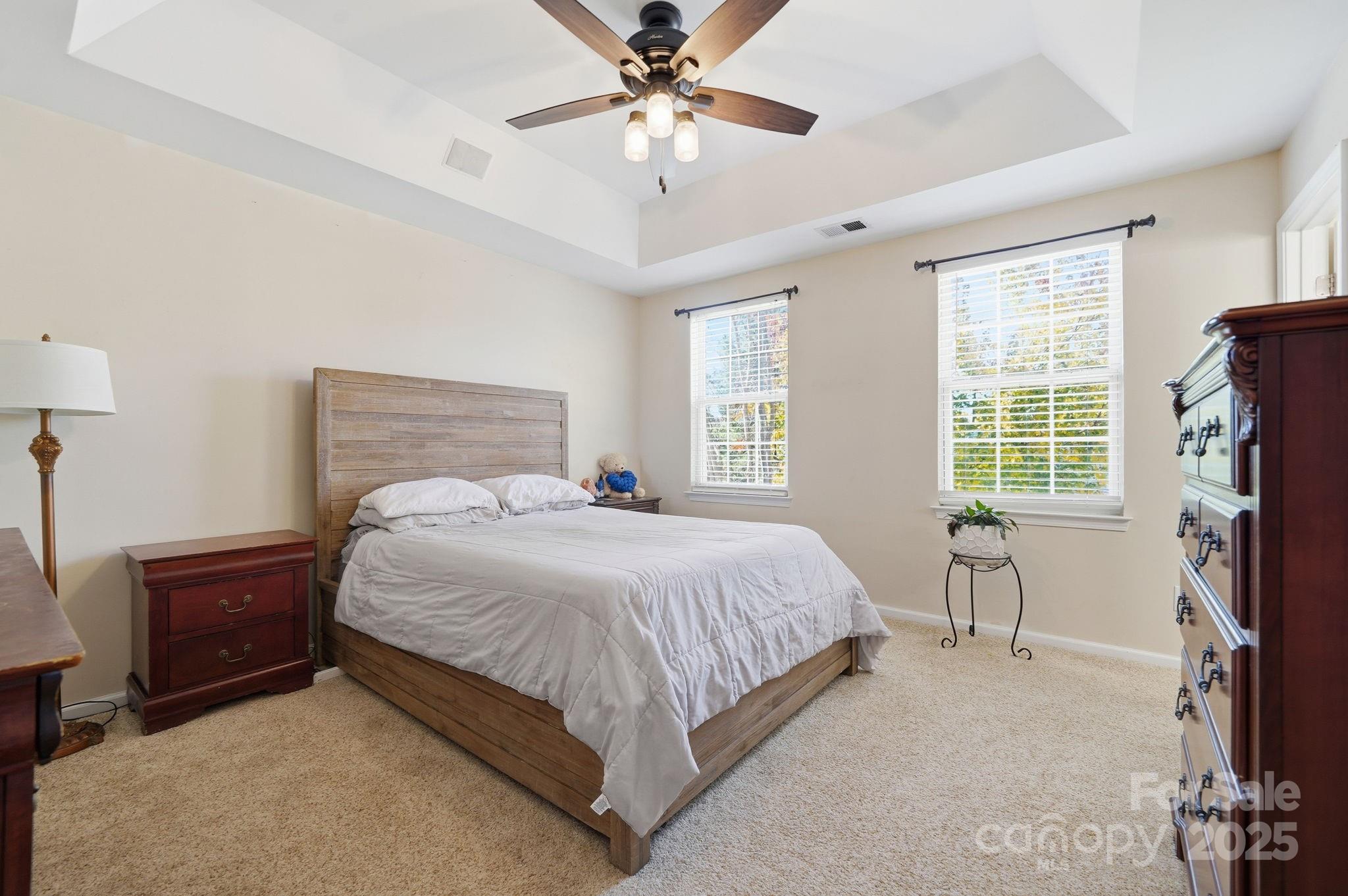 110 Nahcotta Drive Mooresville, NC 28115 - Photo 15 of 29 a bedroom with a bed and a chandelier
