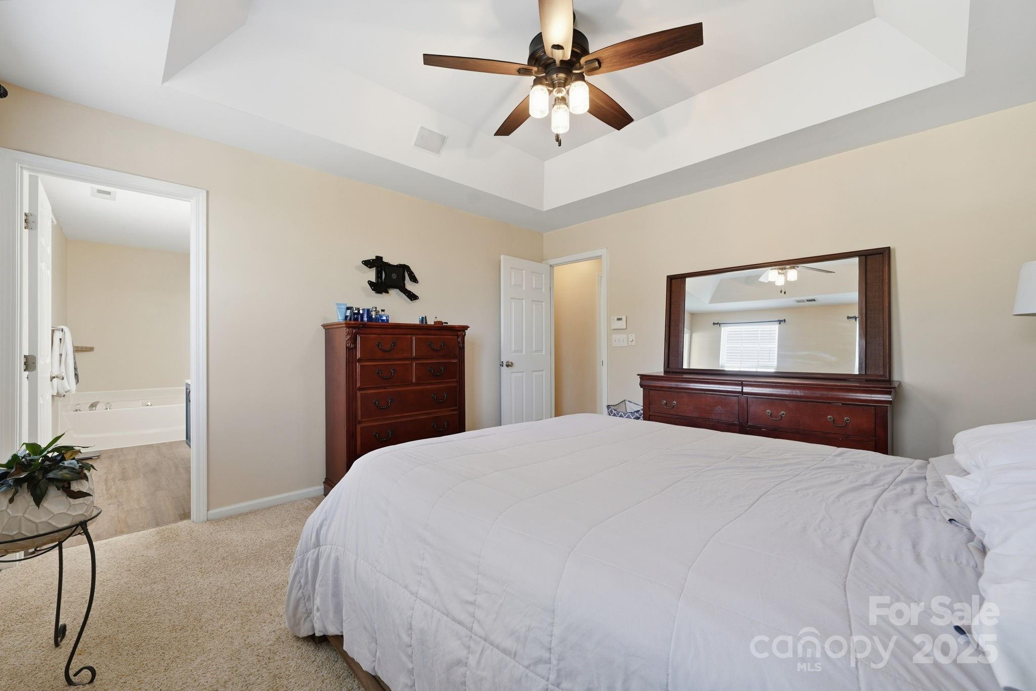 110 Nahcotta Drive Mooresville, NC 28115 - Photo 16 of 29 a bedroom with a bed and a chandelier