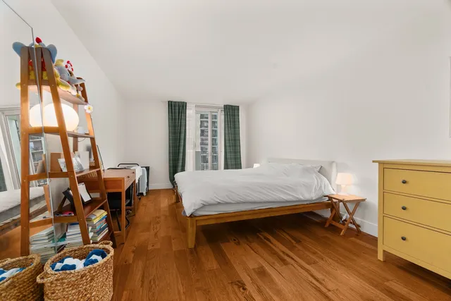 a bedroom with a bed and wooden floor