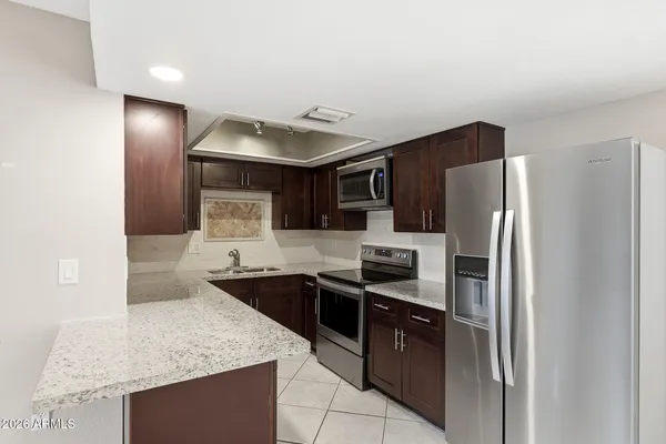 a kitchen with stainless steel appliances granite countertop a sink and stove top oven