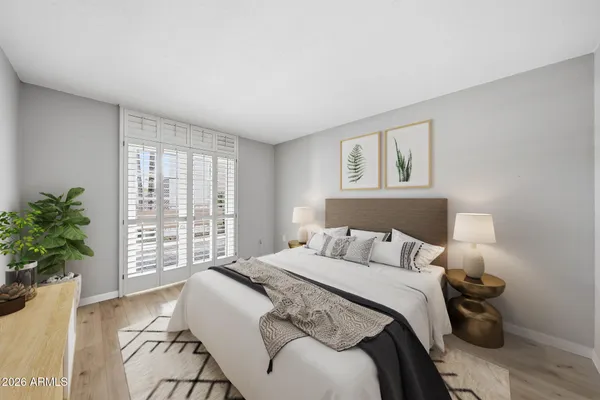 a bedroom with a large bed and potted plant