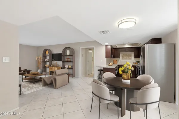 a living room with furniture a computer on a desk and kitchen view