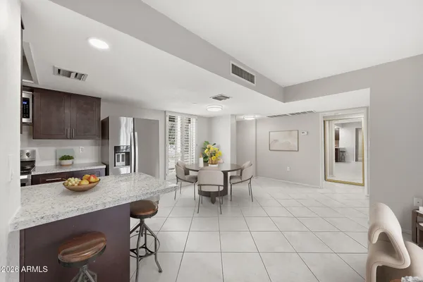 a kitchen with a dining table chairs and living room view