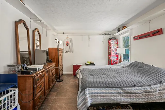 a bedroom with a bed and a flat tv screen on the dresser