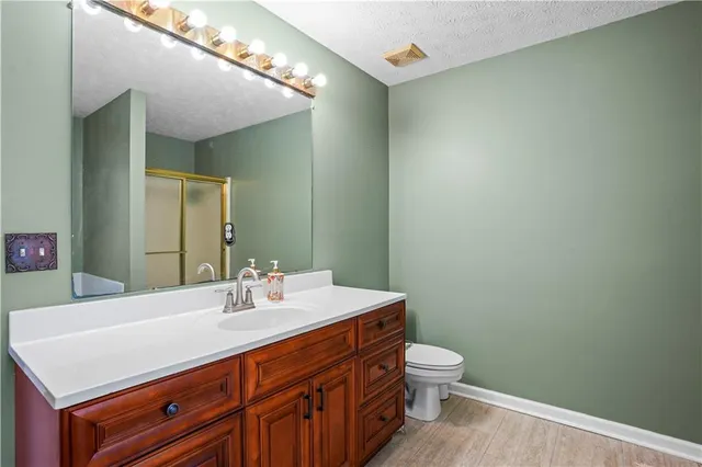 a bathroom with a sink a toilet and mirror