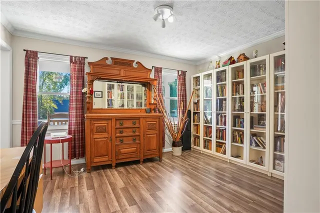 a view of a bedroom with wooden floor and windows