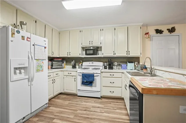 a kitchen with white cabinets and white appliances