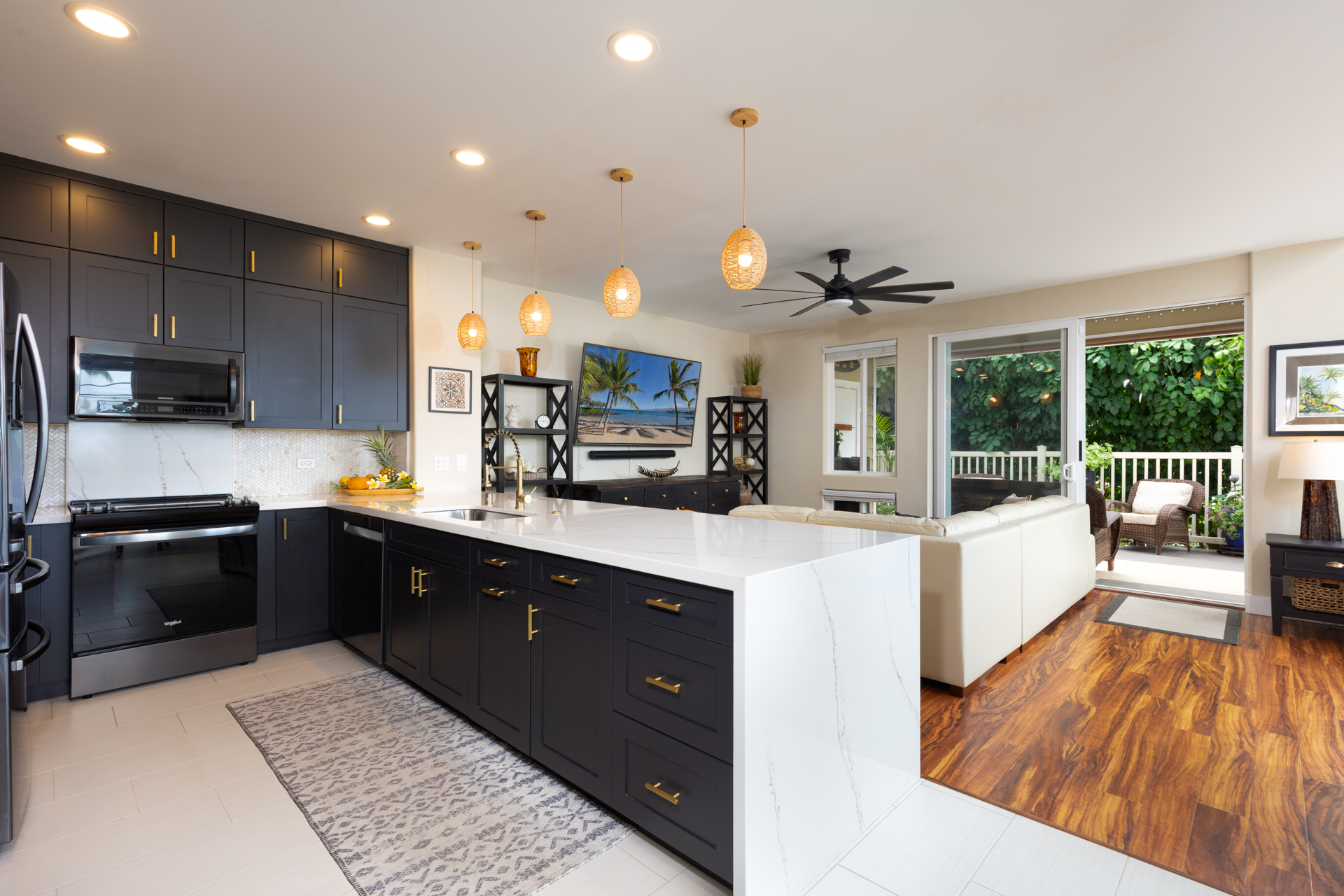 75-6009 Alii Drive, Unit A4 Kailua-Kona, HI 96740 - Photo 12 of 27 a kitchen with stainless steel appliances granite countertop a refrigerator a sink dishwasher a stove and a oven with wooden floor