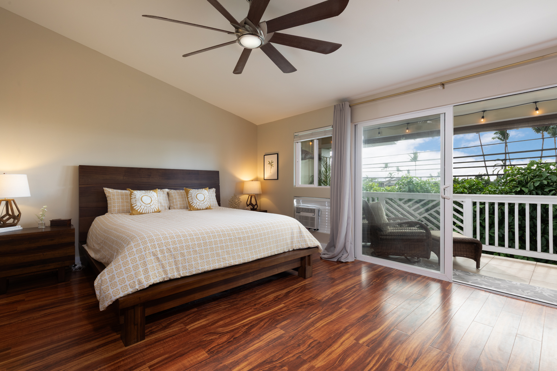 75-6009 Alii Drive, Unit A4 Kailua-Kona, HI 96740 - Photo 15 of 27 a bedroom with a large bed and wooden floor