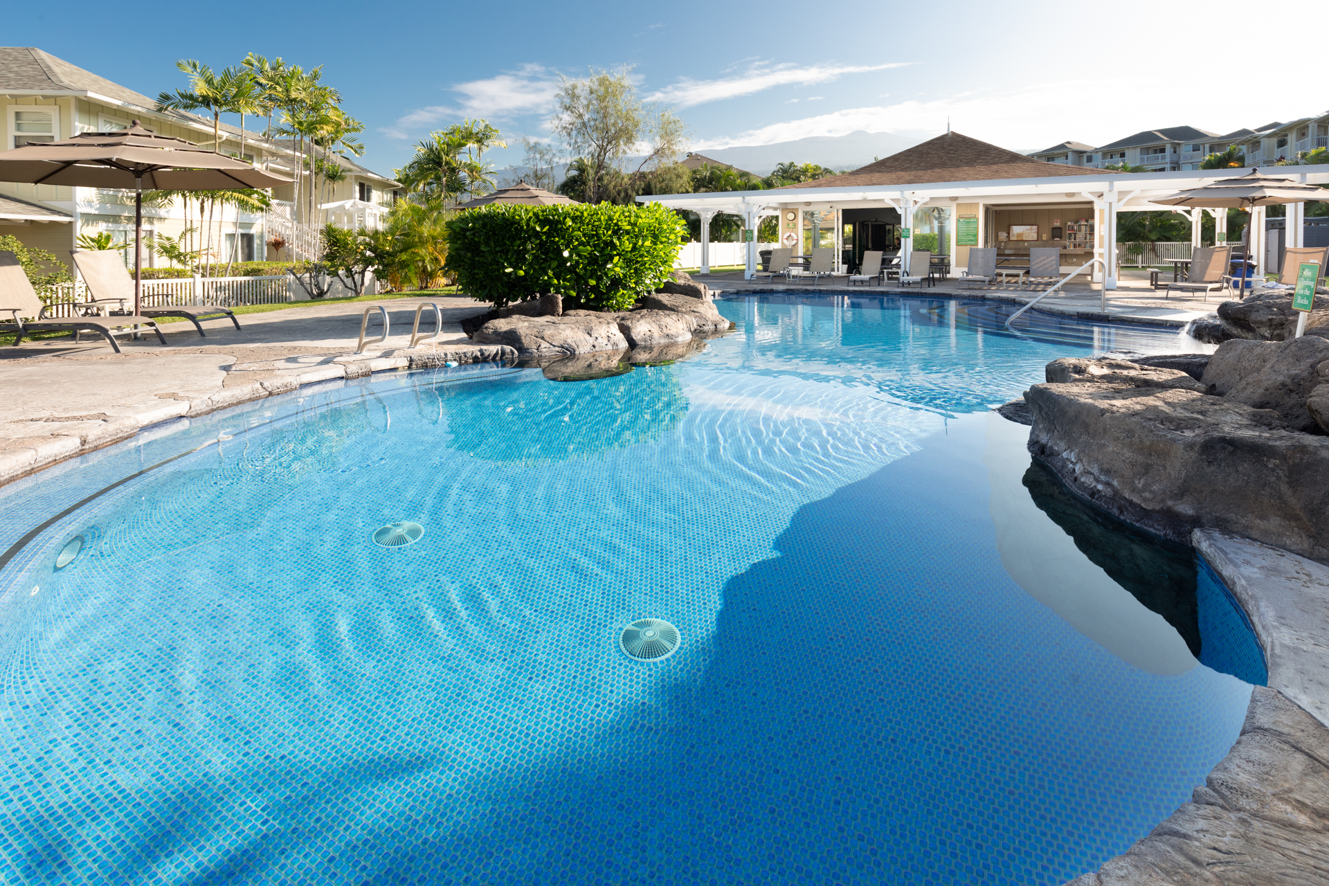75-6009 Alii Drive, Unit A4 Kailua-Kona, HI 96740 - Photo 3 of 27 a front view of a house with garden