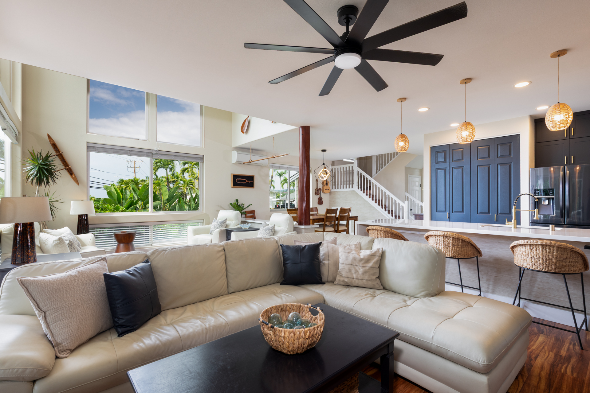 75-6009 Alii Drive, Unit A4 Kailua-Kona, HI 96740 - Photo 8 of 27 a living room with furniture a chandelier and a large window