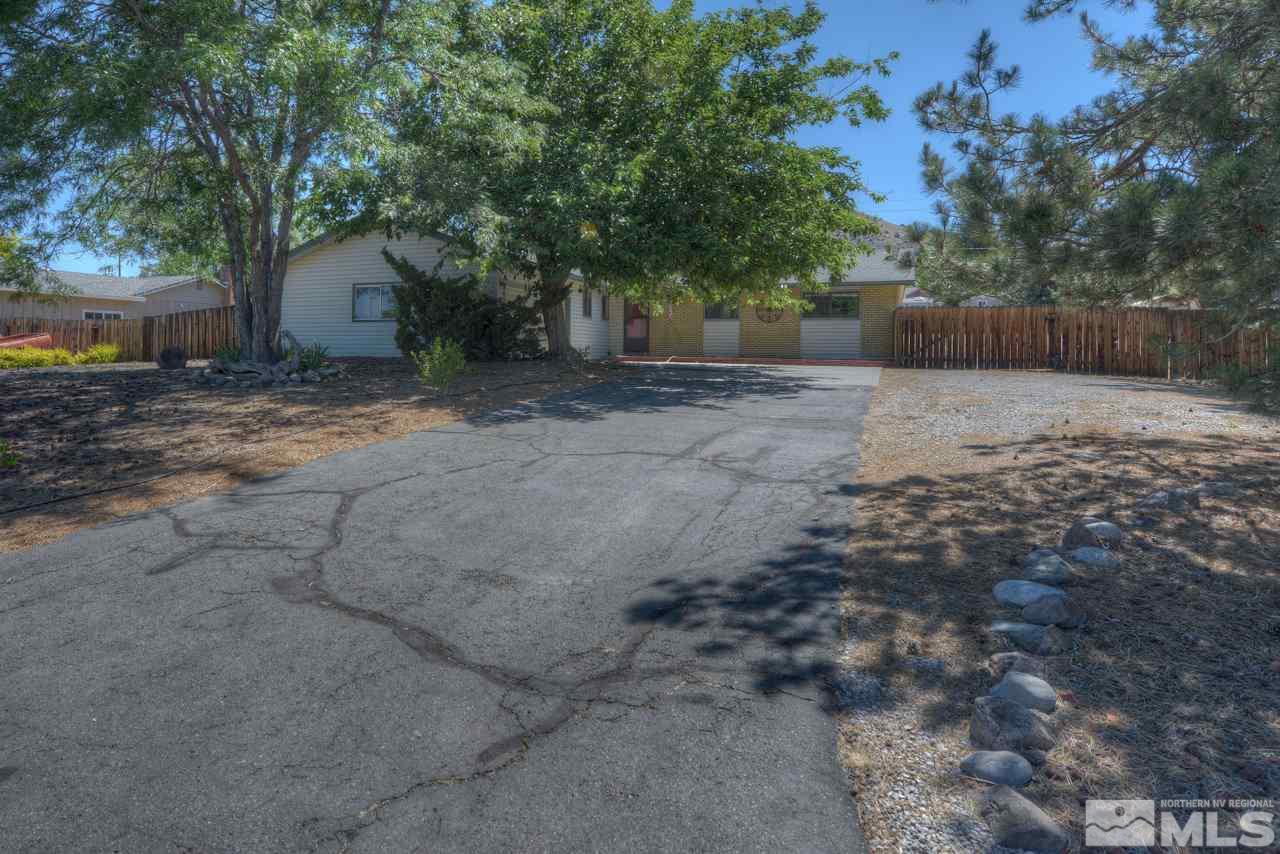 14240 Chamy Drive Reno, NV 89521 - Photo 1 of 1 a view of a backyard with large trees and wooden fence