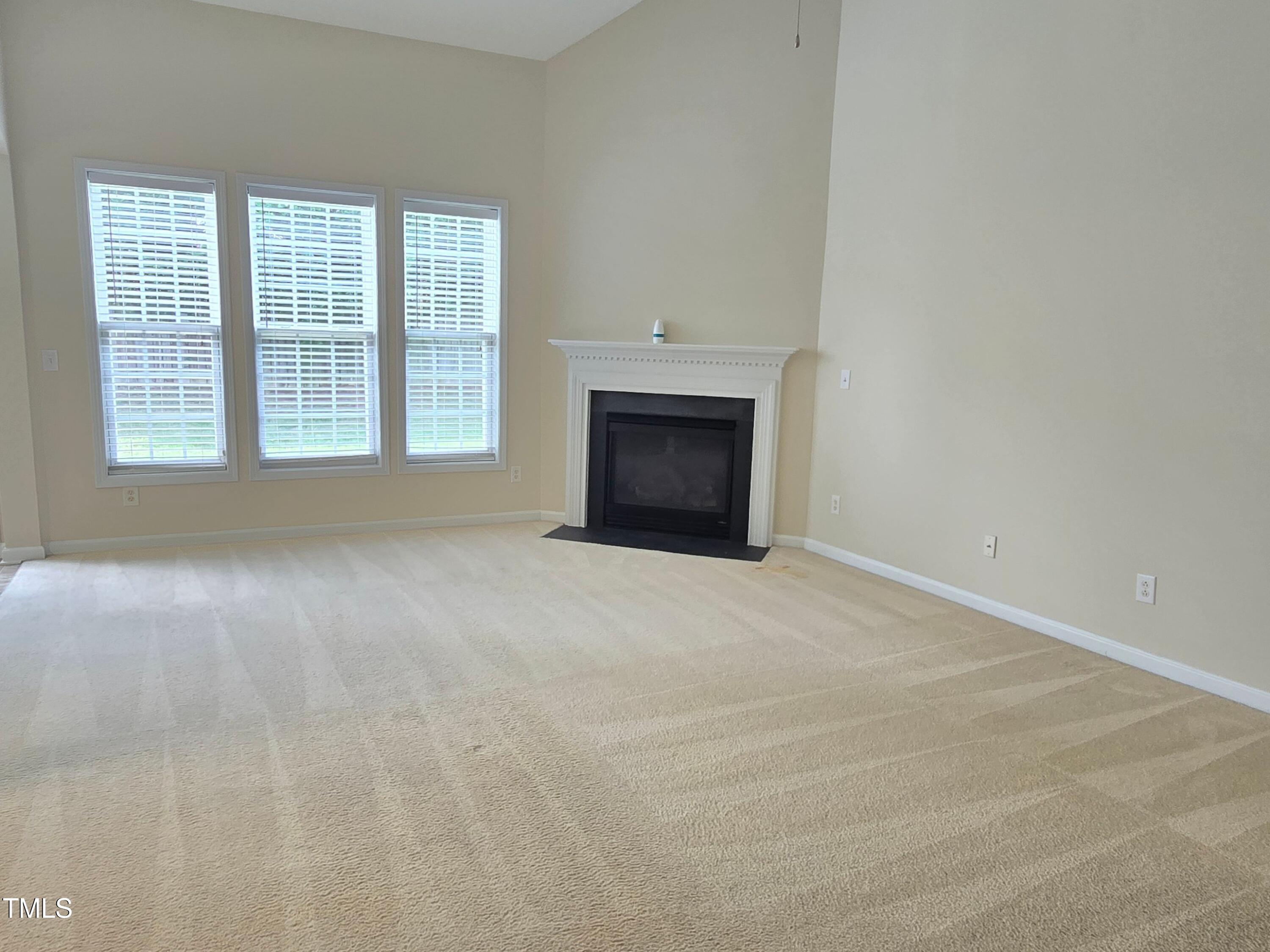 2330 Lazy River Drive Raleigh, NC 27610 - Photo 13 of 31 an empty room with a fireplace and windows