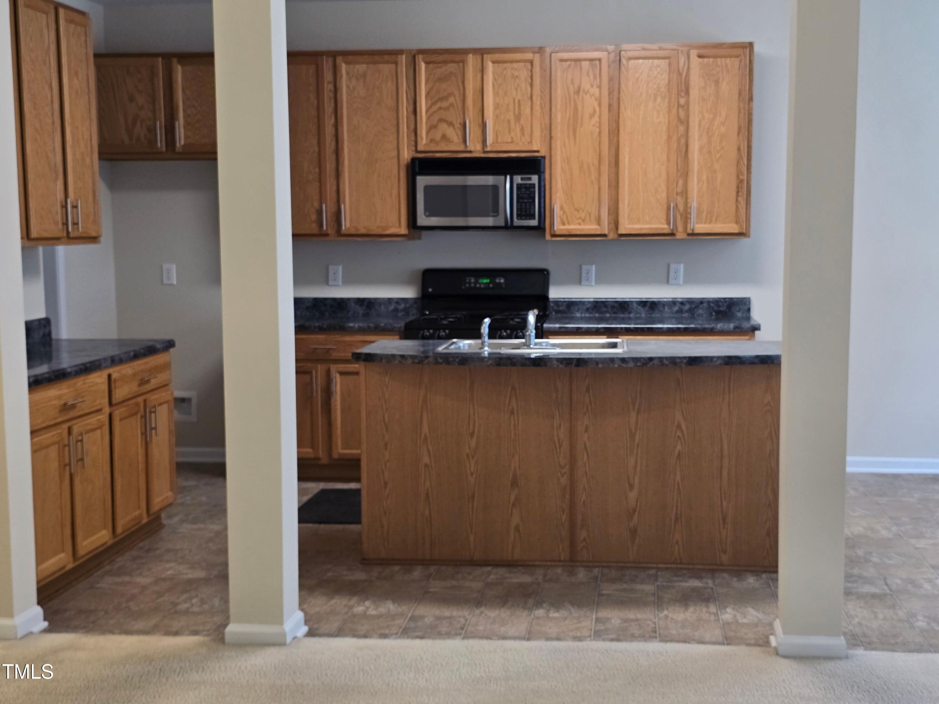 2330 Lazy River Drive Raleigh, NC 27610 - Photo 15 of 31 a kitchen with a stove and a microwave