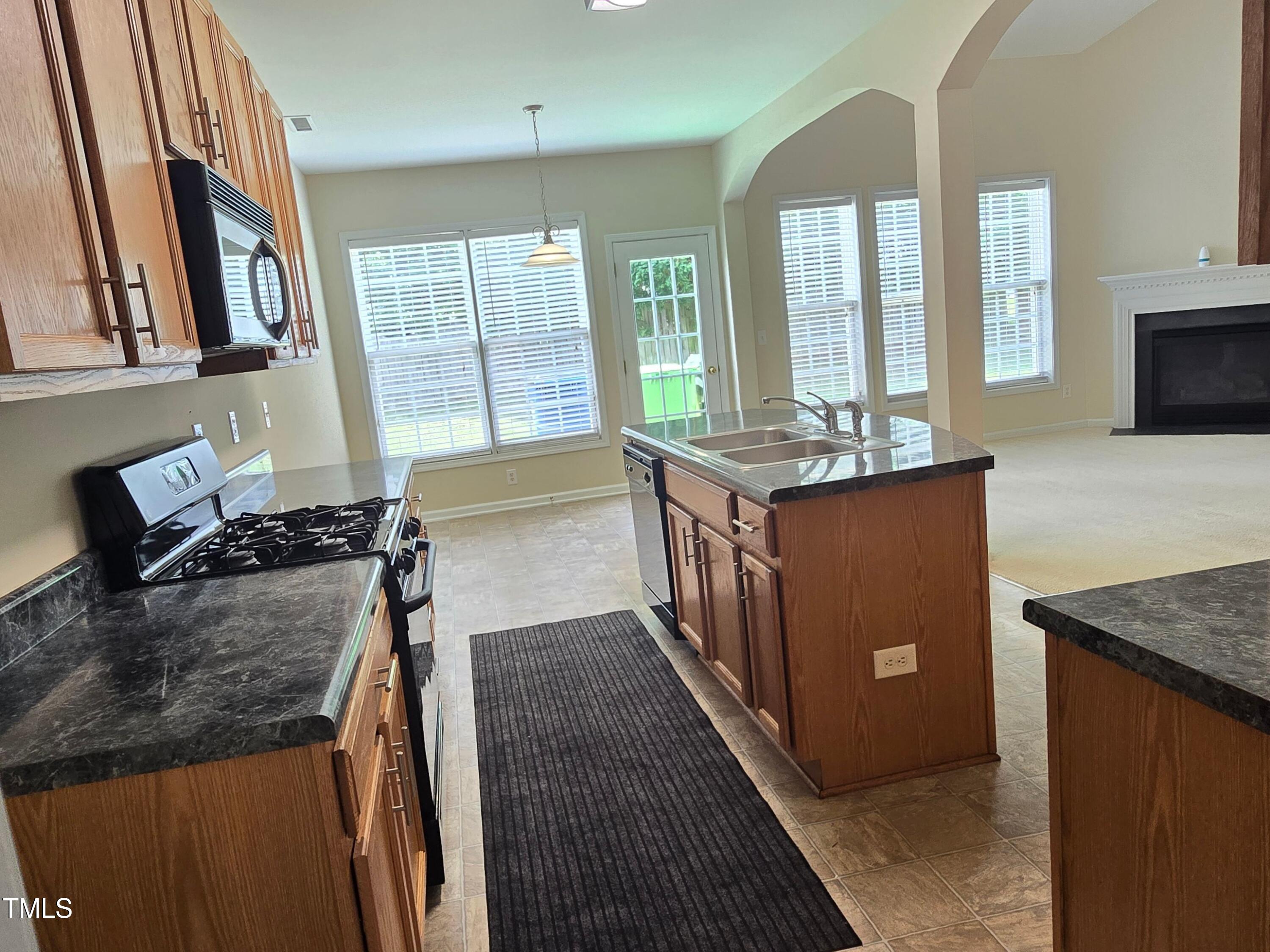 2330 Lazy River Drive Raleigh, NC 27610 - Photo 16 of 31 a kitchen with granite countertop a stove a sink and a refrigerator