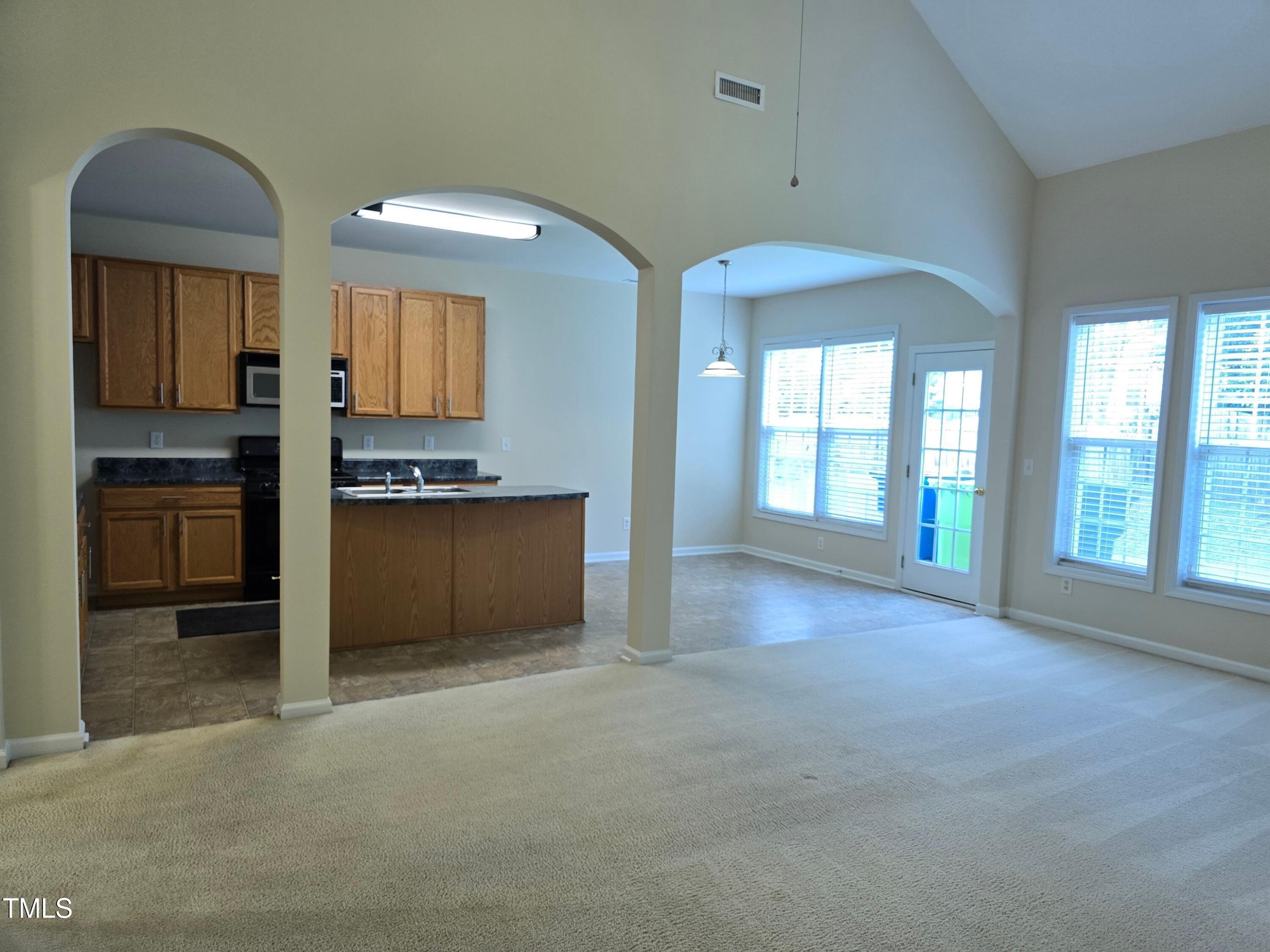 2330 Lazy River Drive Raleigh, NC 27610 - Photo 19 of 31 an empty room with a kitchen and windows
