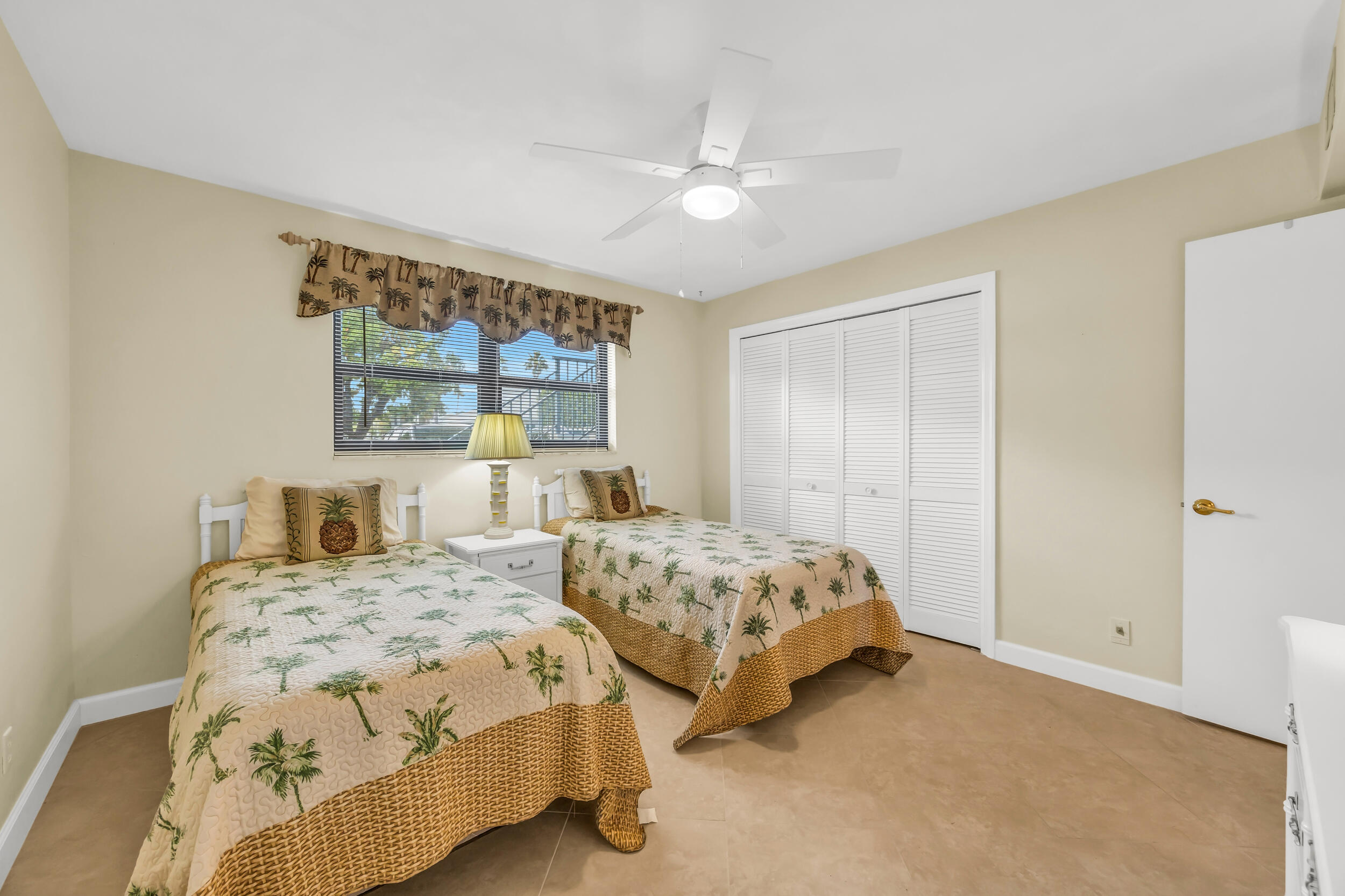755 Saturn Street, Unit G101 Jupiter, FL 33477 - Photo 29 of 31 a bedroom with two beds and a large window