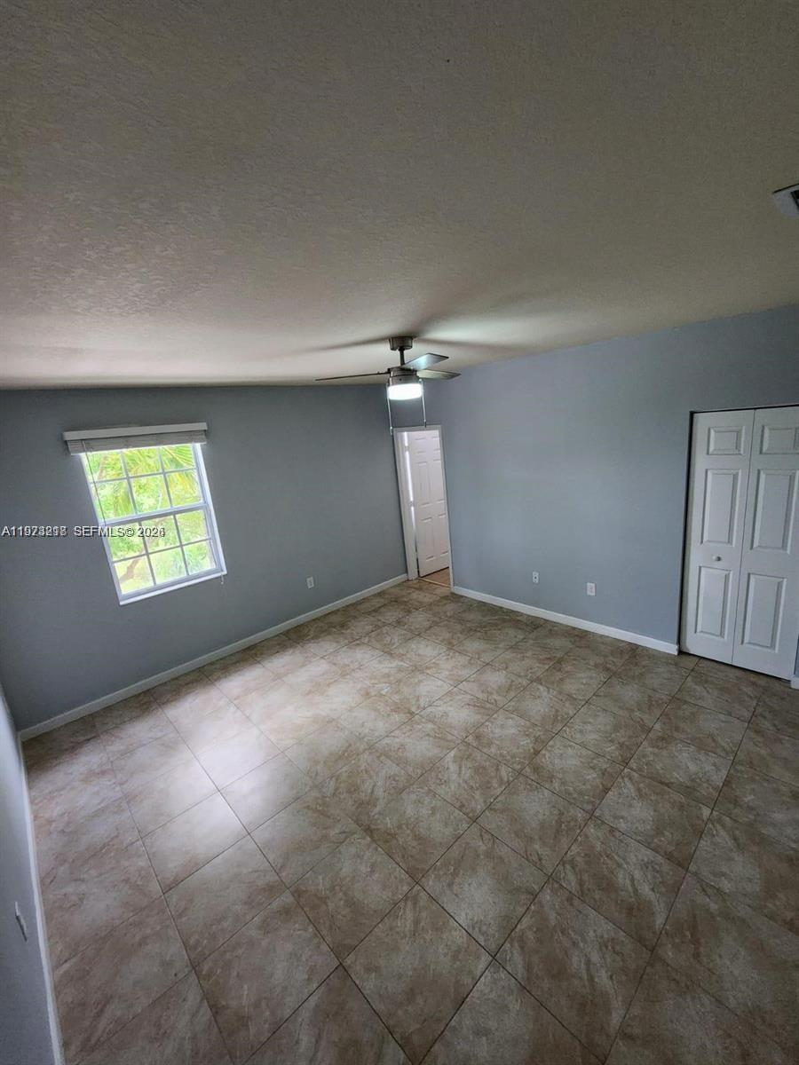 17005 Southwest 96th Street, Unit MAIN Miami, FL 33196 - Photo 12 of 19 an empty room with windows