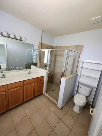 a bathroom with a double vanity sink toilet and shower