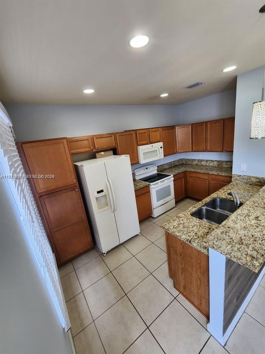 17005 Southwest 96th Street, Unit MAIN Miami, FL 33196 - Photo 4 of 19 a kitchen with stainless steel appliances granite countertop a sink and a stove