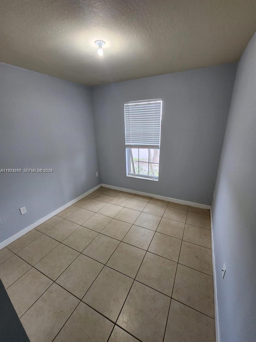 17005 Southwest 96th Street, Unit MAIN Miami, FL 33196 - Photo 7 of 19 a view of an empty room and a window