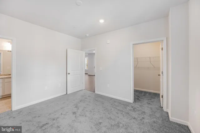 a spacious bathroom with a granite countertop sink toilet a mirror and a glass door shower