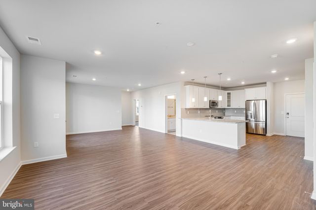a view of kitchen with kitchen island sink refrigerator and window