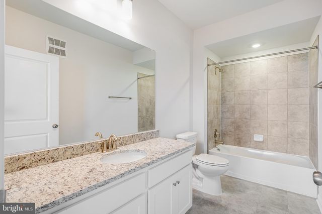 a bathroom with a granite countertop sink a toilet and bathtub