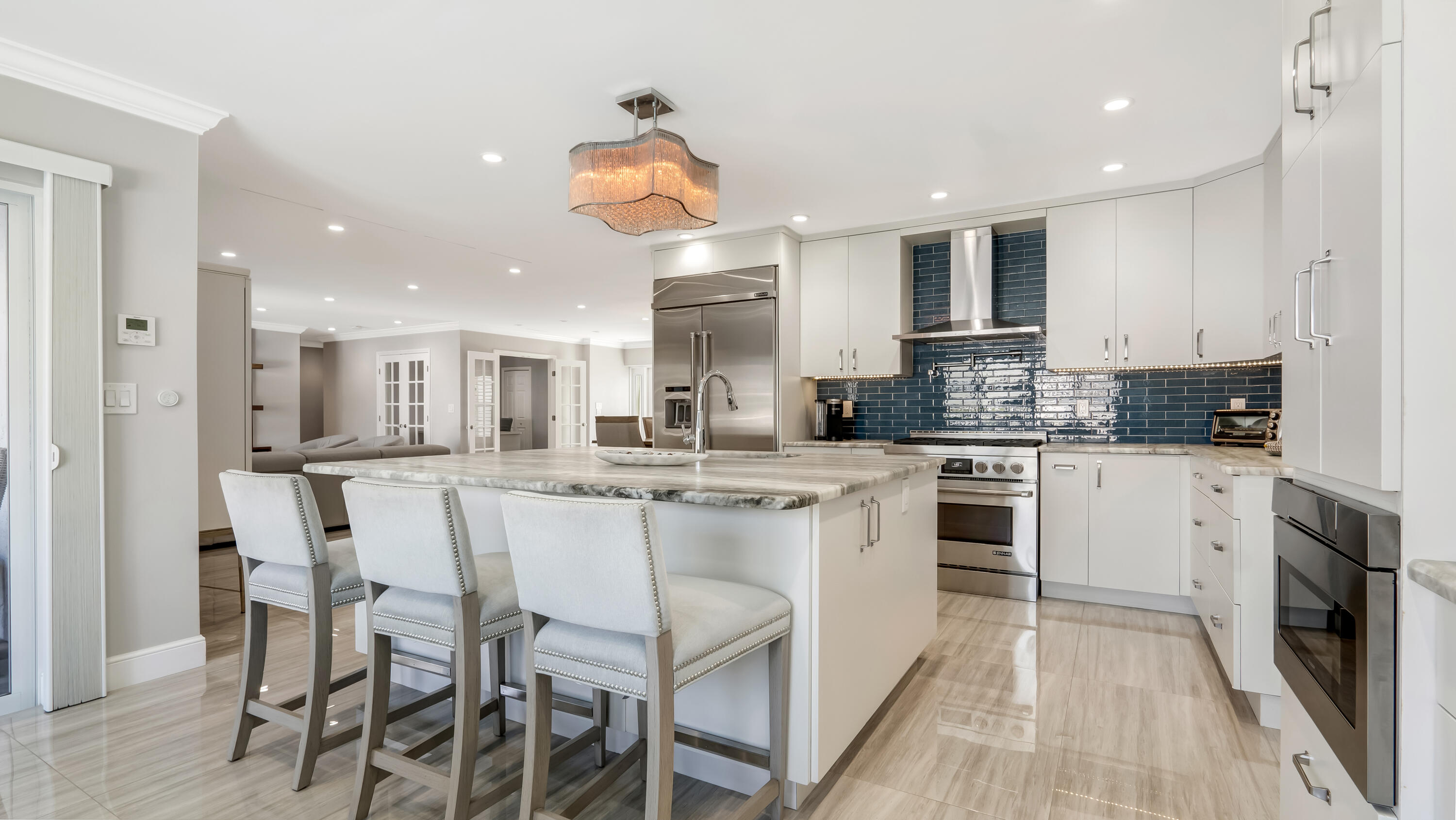 831 Dover Street Boca Raton, FL 33487 - Photo 30 of 71 a kitchen with stainless steel appliances kitchen island granite countertop a table chairs sink and cabinets