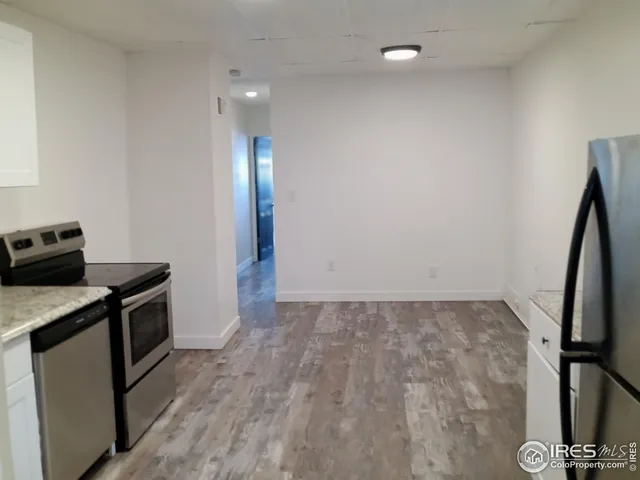 a view of a kitchen with fridge and wooden floor
