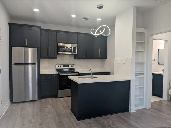 a kitchen with a refrigerator a sink and cabinets