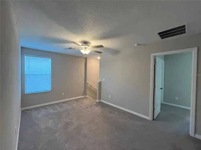 an empty room with a ceiling fan and a window