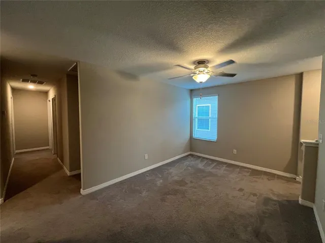 an empty room with a ceiling fan and a window