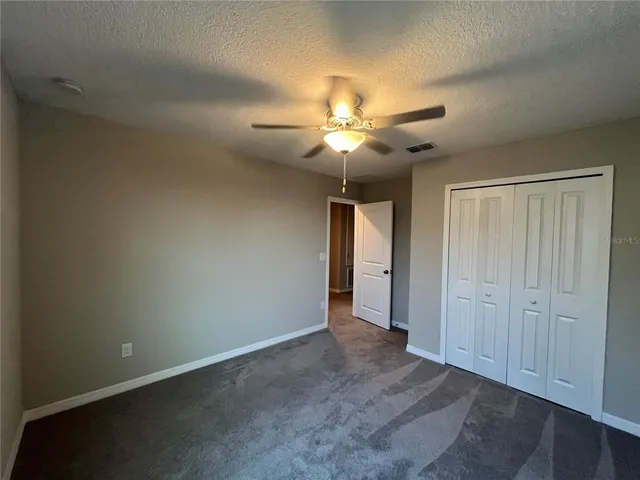 an empty room with a window and a fan