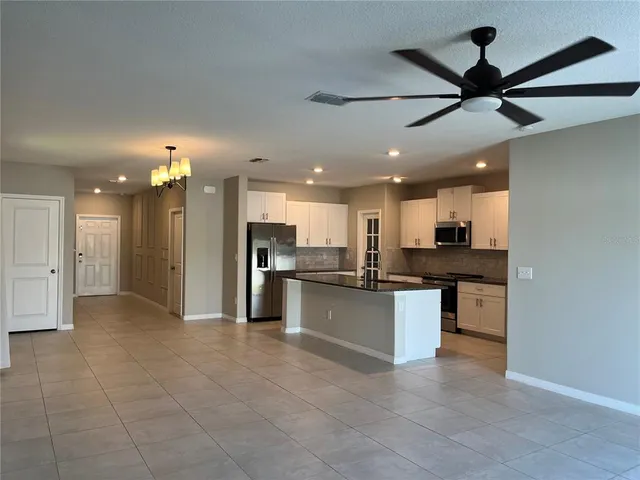 a large kitchen with stainless steel appliances granite countertop a refrigerator and a stove top oven