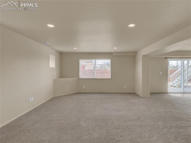 8599 Tibbs Road Peyton, CO 80831 - Photo 32 of 38 Basement was finished in 2004, sparkling clean, carpets recently cleaned, huge family room space in this walk-out basement!