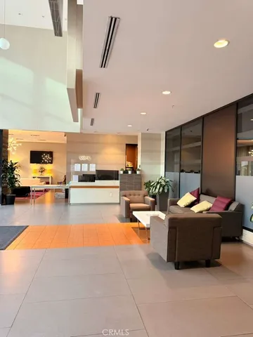 a living room with furniture a chandelier and a dining table with potted plants
