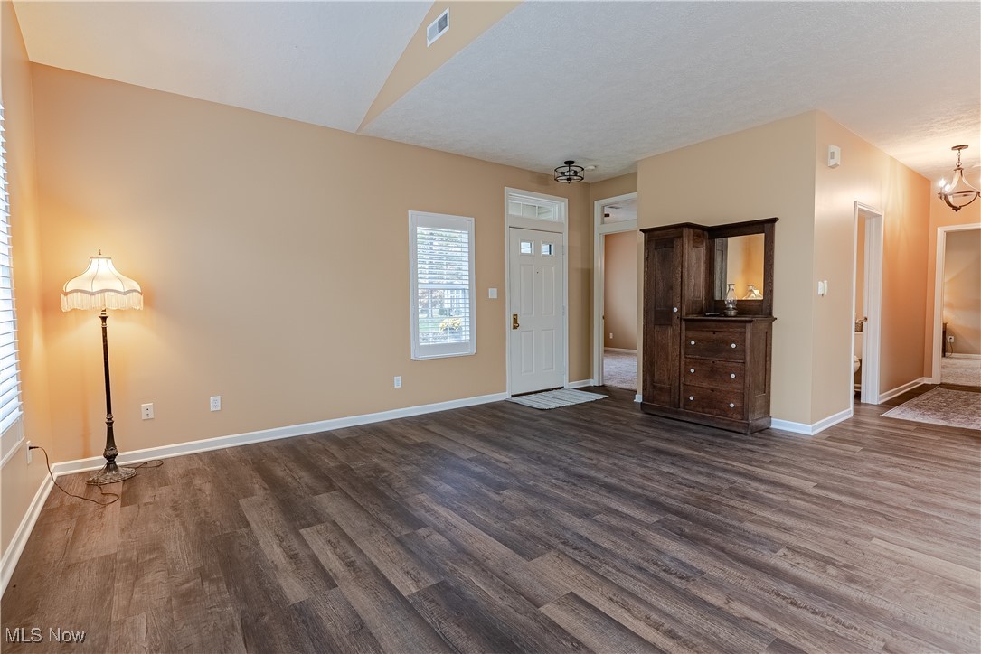 5645 Clingan Road, Unit 23B Struthers, OH 44471 - Photo 13 of 38 Unfurnished living room with dark wood-style flooring and a chandelier