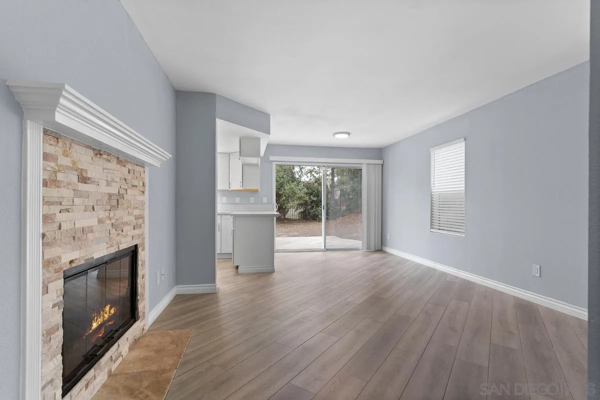13948 Carmel Ridge Road San Diego, CA 92128 - Photo 11 of 26 a view of empty room with wooden floor and fireplace