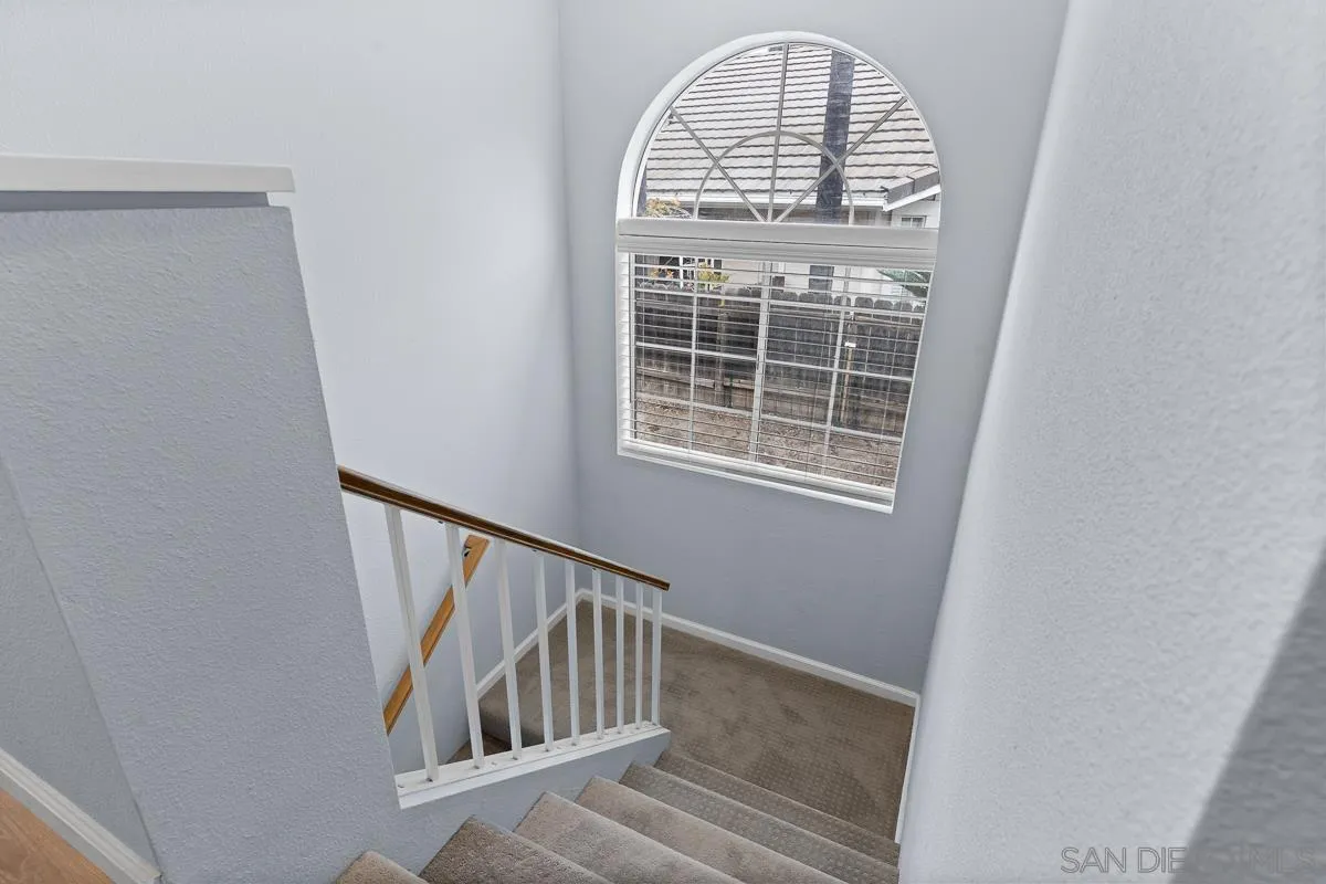 13948 Carmel Ridge Road San Diego, CA 92128 - Photo 13 of 26 a view of staircase with white walls and a window