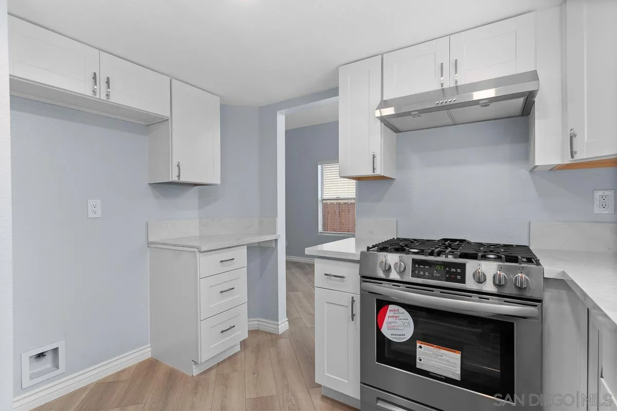 13948 Carmel Ridge Road San Diego, CA 92128 - Photo 8 of 26 a kitchen with white cabinets and appliances