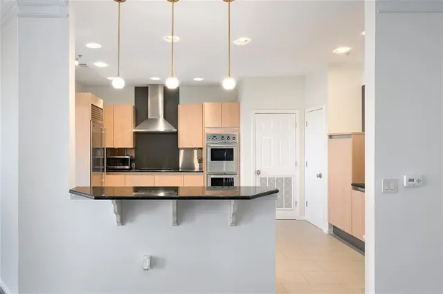 a view of kitchen with kitchen island a sink stainless steel appliances and cabinets